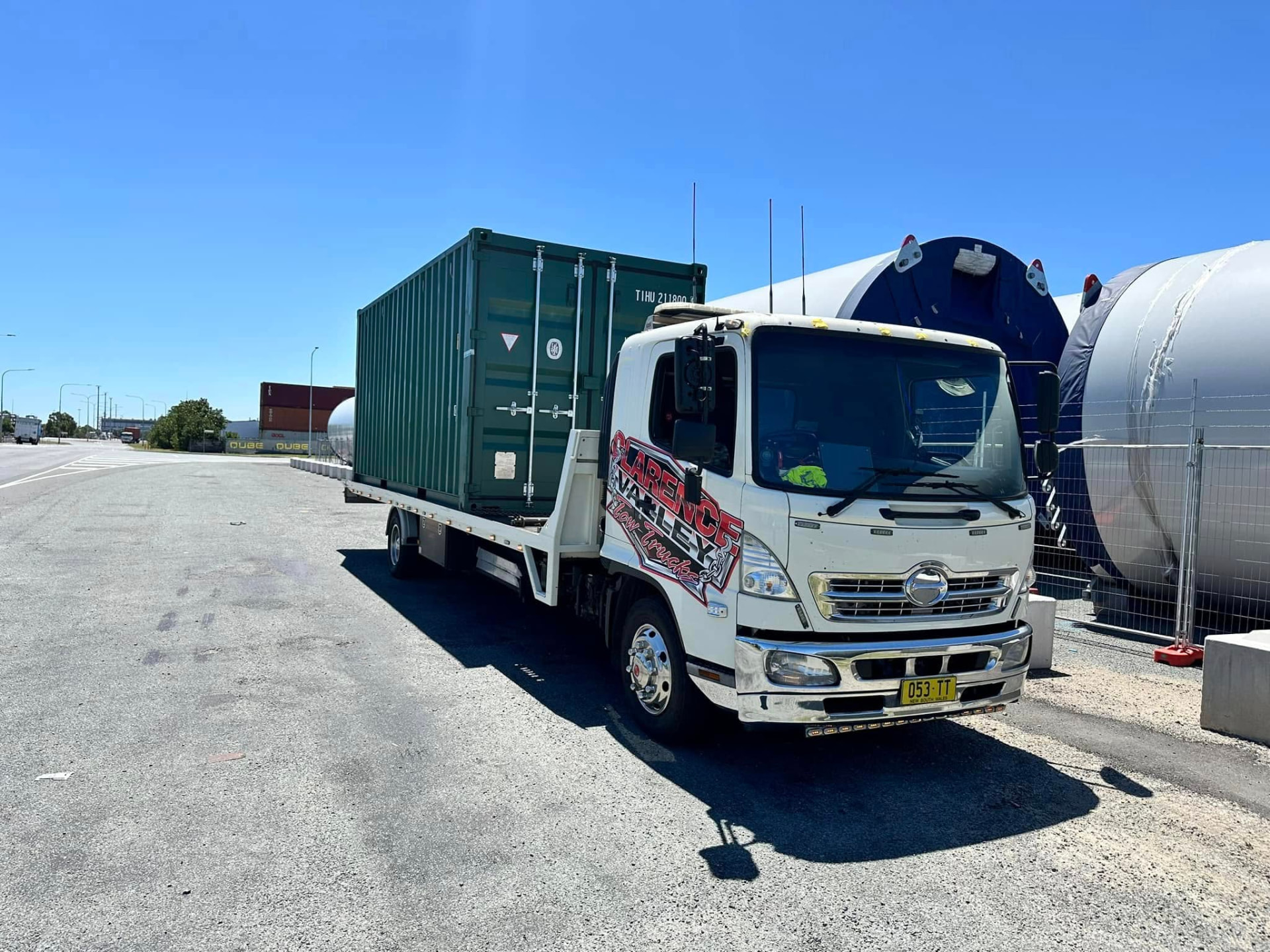 Clarence Valley Tow Trucks tilt tray carrying a green shipping container at a port yard