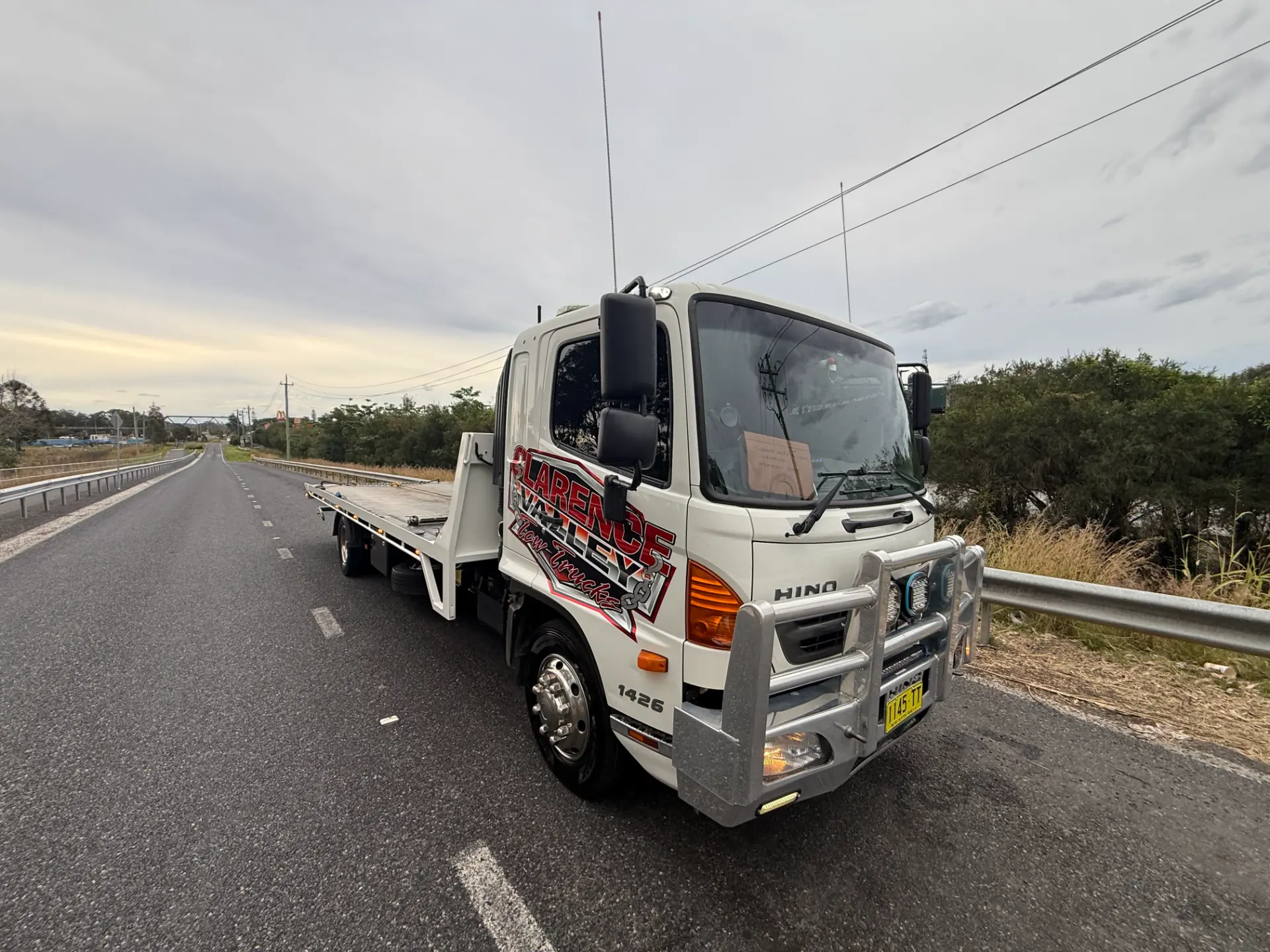 Front three-quarter view of the tow truck stopped on a country highway at last light