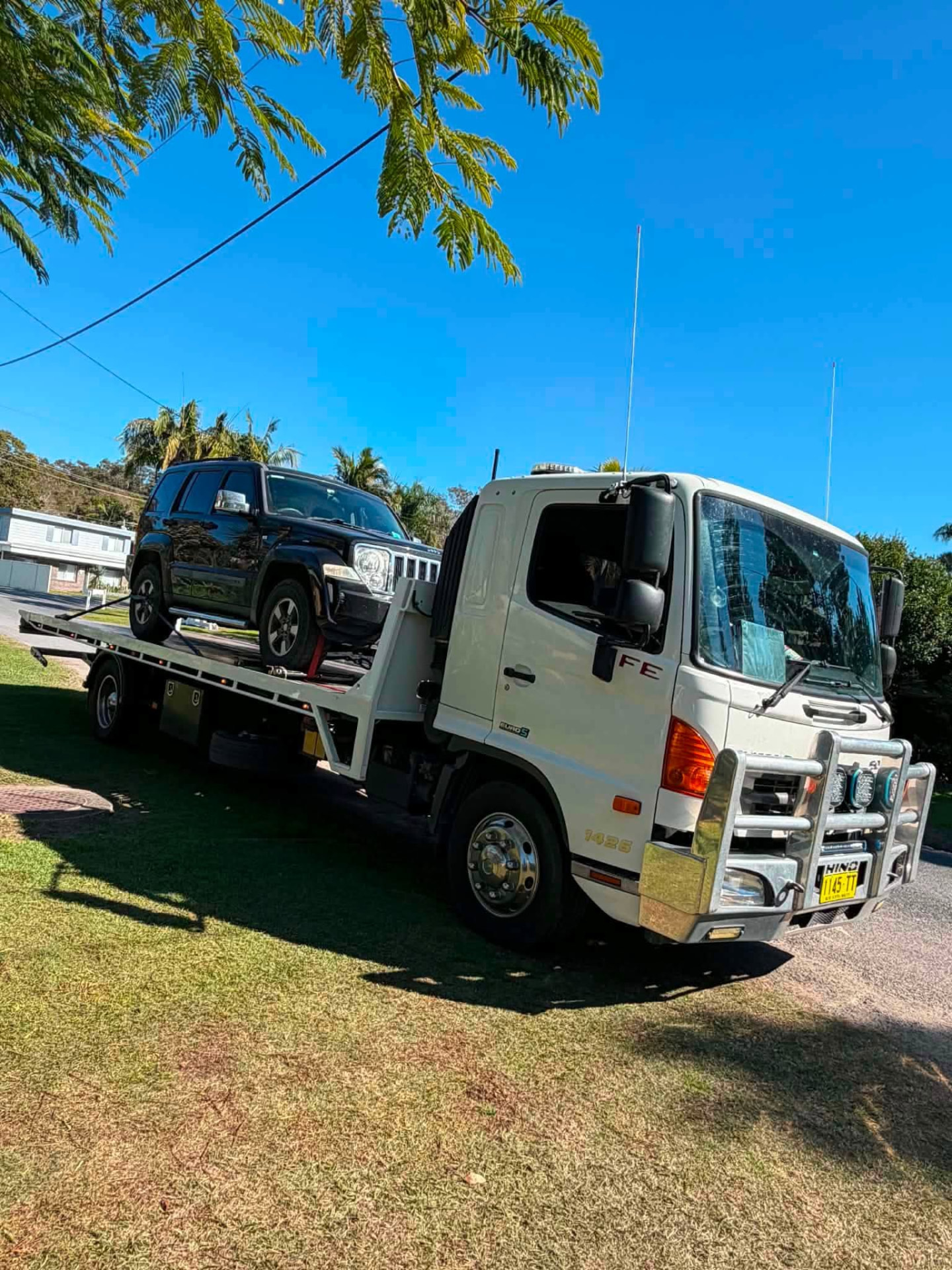 Black four-wheel drive loaded on a Clarence Valley Tow Trucks tilt tray for towing in Grafton