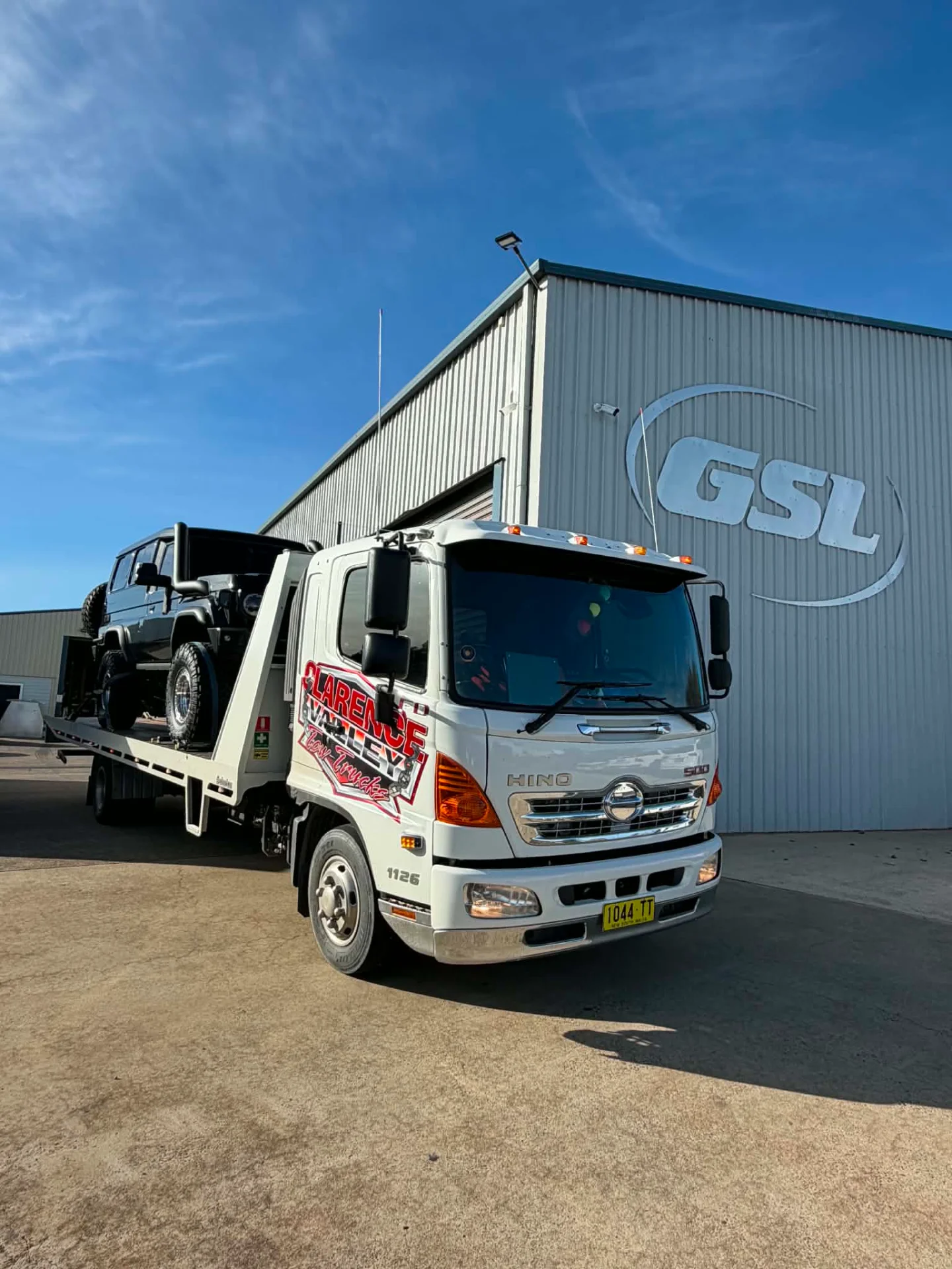 Side view of a four-wheel drive on the tray outside a warehouse