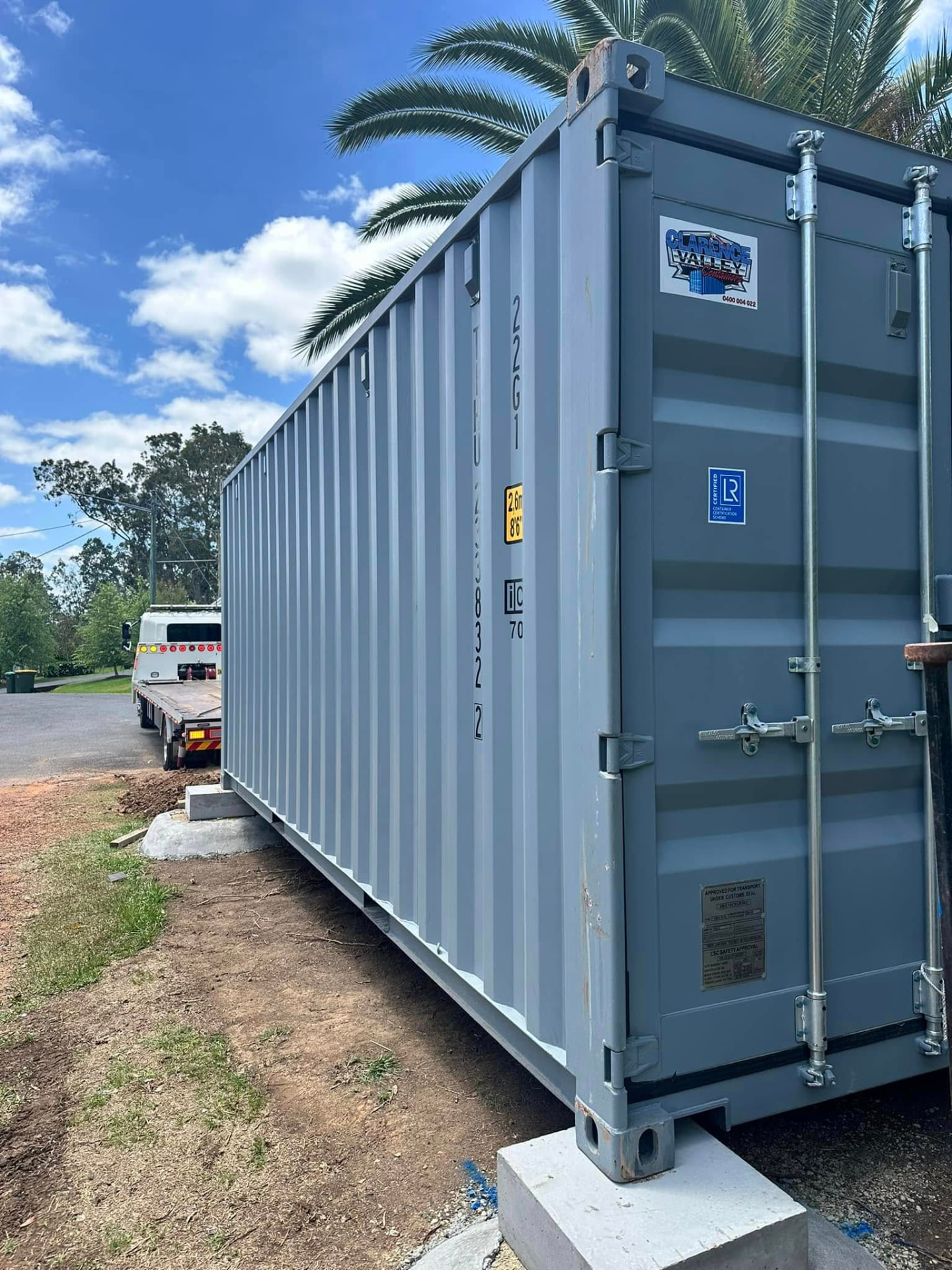 Grey shipping container placed on concrete footings on a Northern NSW property after transport
