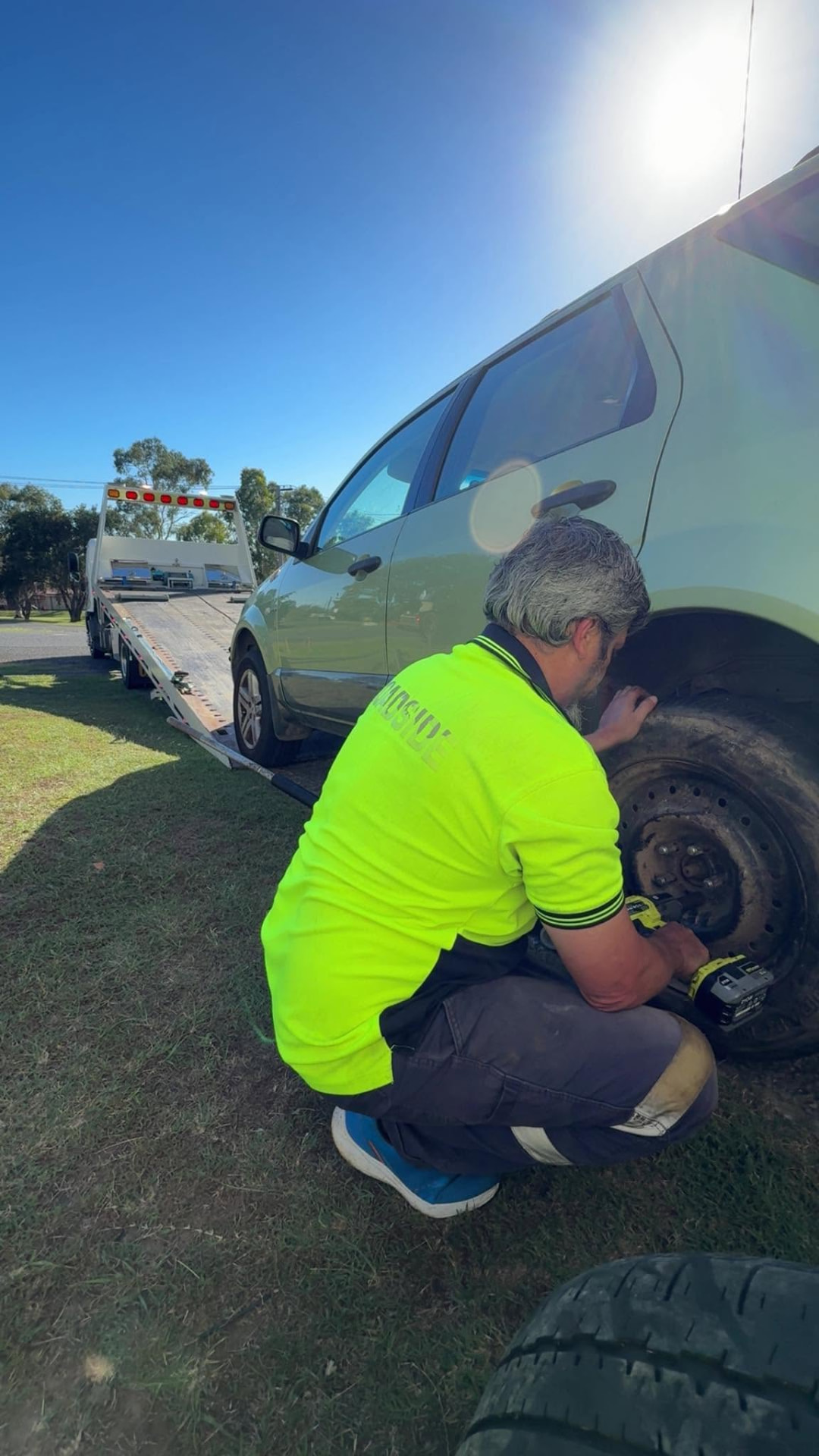 Clarence Valley Tow Trucks operator changing a flat tyre at a roadside assistance callout