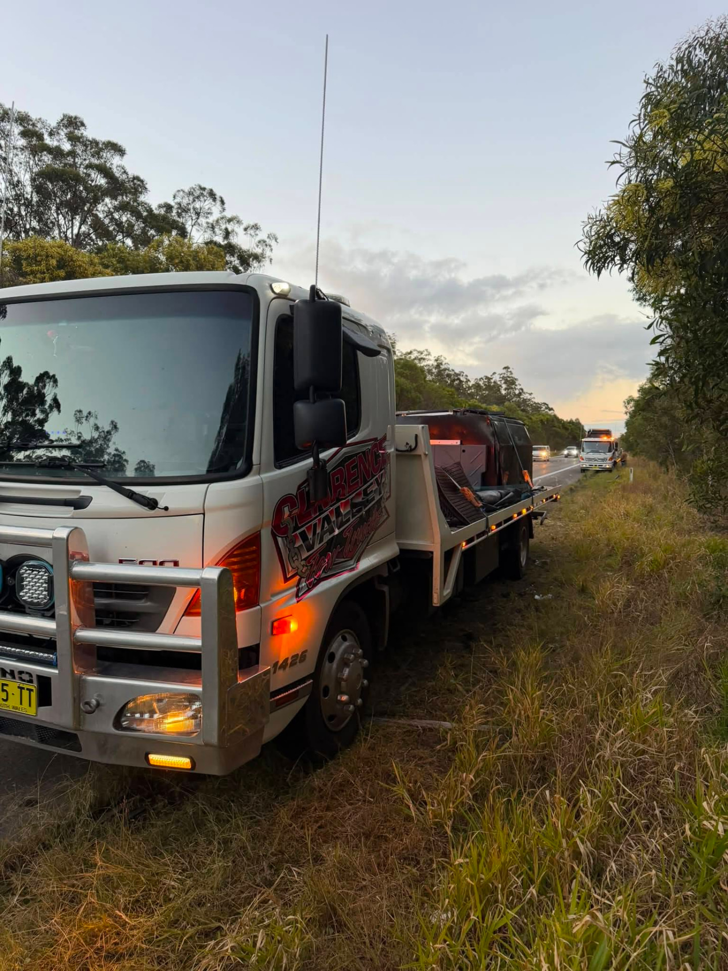 Clarence Valley Tow Trucks tow truck on a highway shoulder at dusk during a roadside recovery near Maclean