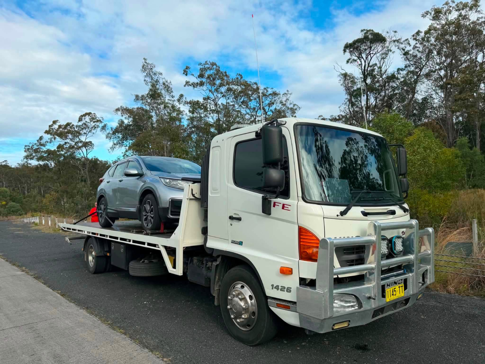 Silver SUV secured on a Clarence Valley Tow Trucks tilt tray beside a Grafton highway