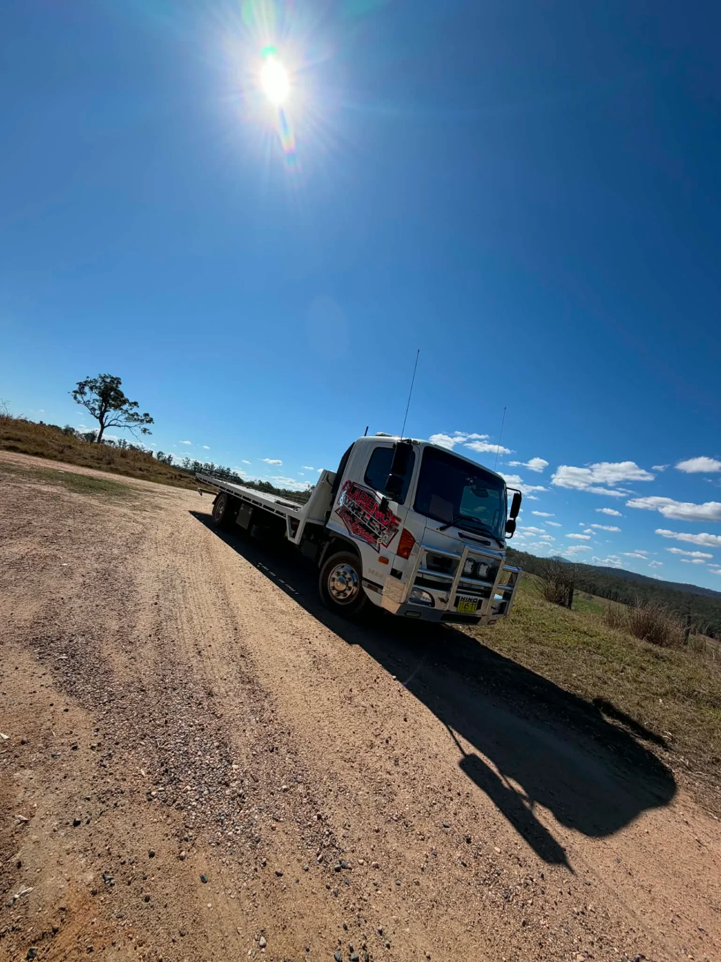 Tow truck on a dirt track with the sun overhead