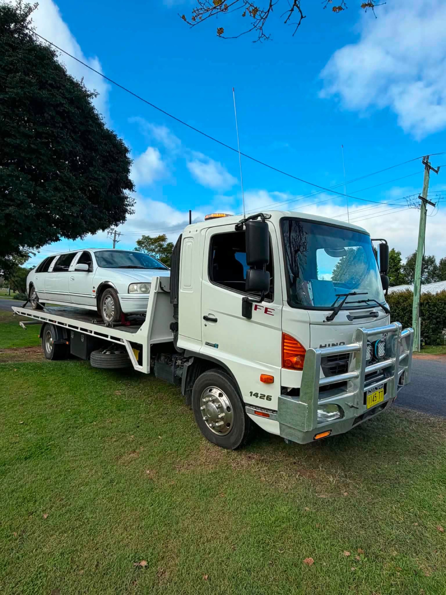 White sedan loaded on a Clarence Valley Tow Trucks tilt tray ready for towing