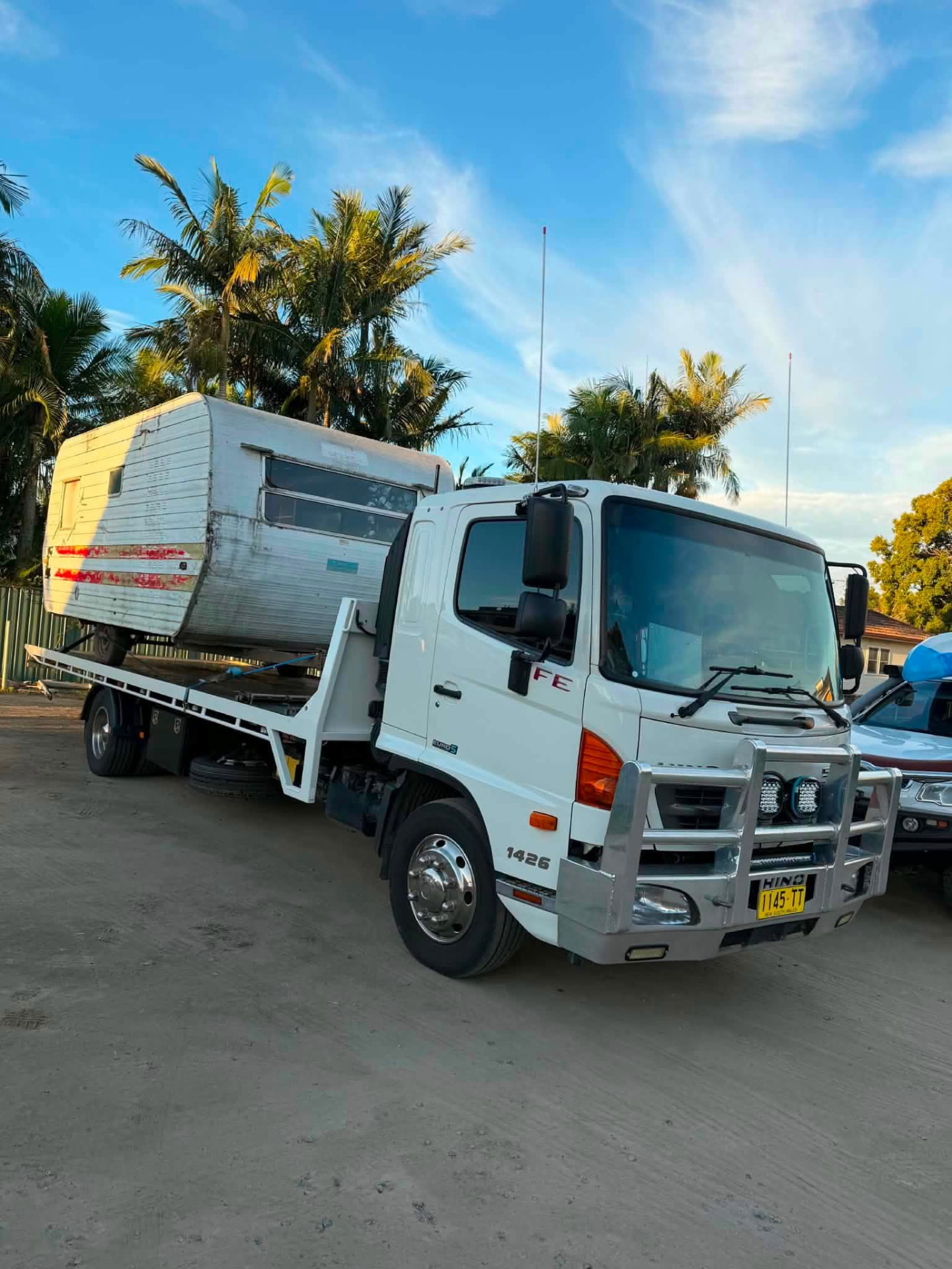 Caravan loaded on a tilt tray tow truck at sunset in the Clarence Valley