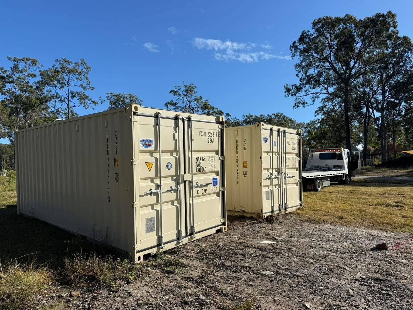 Two shipping containers delivered on site in the Clarence Valley with the Clarence Valley Tow Trucks tilt tray alongside